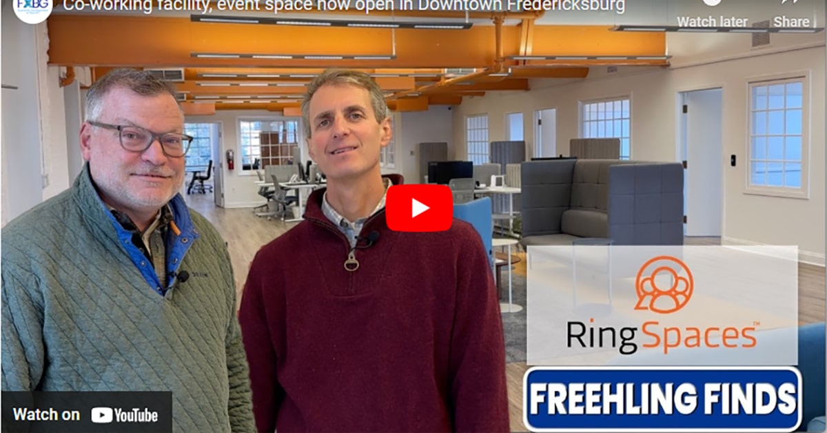 This image features Neil Darling, owner of RingSpaces, and Bill Freehling, Fredericksburg's Director of Economic Development and Tourism, standing in the modern coworking space at RingSpaces. The background highlights the open, vibrant workspace with collaborative seating and bright orange ceiling accents. The overlay includes the RingSpaces logo and "Freehling Finds," indicating a promotional or informational video about the coworking and event facility in Downtown Fredericksburg.